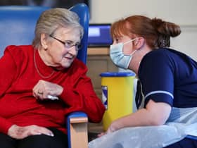 Resident Annie Innes, 90, talks with a healthcare worker after receiving the Pfizer/BioNTech COVID-19 vaccine at the Abercorn House Care Home in Hamilton.