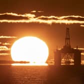 The sun rising behind a redundant oil platform moored in the Firth of Forth