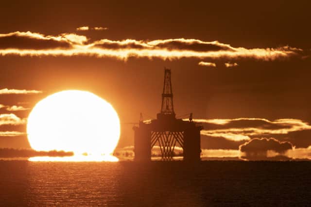 The sun rising behind a redundant oil platform moored in the Firth of Forth