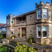 The drive way has space for several cars, and the house has a grand, sweeping staircase for a dramatic entrance.