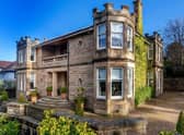 The drive way has space for several cars, and the house has a grand, sweeping staircase for a dramatic entrance.