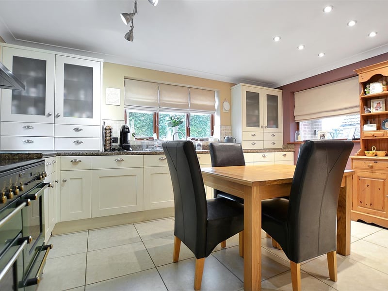 An L-shaped breakfast kitchen, featuring a contemporary fitted kitchen comprising wall cupboards, base units and drawers with granite effect work surfaces above.