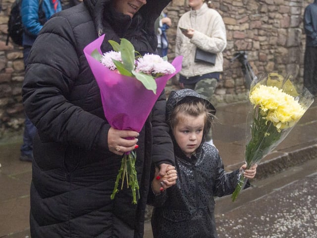 A Mum and her little girl both laid floral tributes outside the Palace after hearing the sad news.