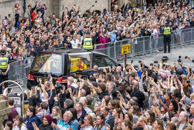 The hearse carrying the coffin of Queen Elizabeth II, draped with the Royal Standard of Scotland, passes down the Royal Mile, Edinburgh, on the journey from Balmoral to the Palace of Holyroodhouse in Edinburgh, where it will lie in rest for a day. Picture date: Sunday September 11, 2022.