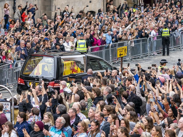 The hearse carrying the coffin of Queen Elizabeth II, draped with the Royal Standard of Scotland, passes down the Royal Mile, Edinburgh, on the journey from Balmoral to the Palace of Holyroodhouse in Edinburgh, where it will lie in rest for a day. Picture date: Sunday September 11, 2022.