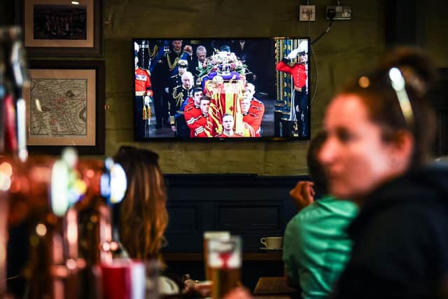 Customers in The Scotsman's Lounge in central Edinburgh watch the televised State Funeral Service