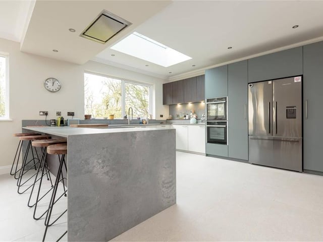 The German kitchen by Stormer has a range of quality appliances, matching work surfaces, a breakfast bar and tiled flooring.
