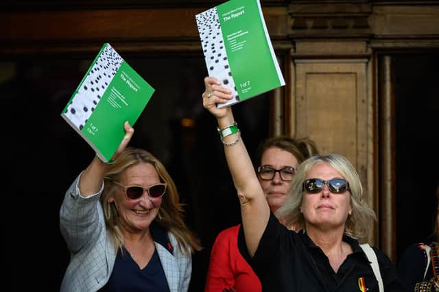 People affected by the infected blood scandal hold up copies of the final report as they leave the Methodist Central Hall in London following the release of the findings of the public inquiry on Monday. (Picture: Leon Neal/Getty Images)