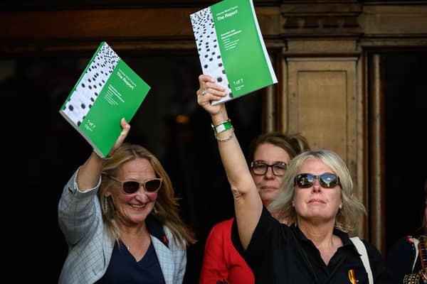 People affected by the infected blood scandal hold up copies of the final report as they leave the Methodist Central Hall in London following the release of the findings of the public inquiry on Monday. (Picture: Leon Neal/Getty Images)