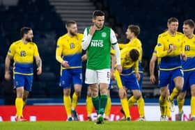 Hibs' Paul McGinn looks on despondently as St Johnstone celebrate their win.