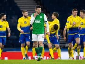 Hibs' Paul McGinn looks on despondently as St Johnstone celebrate their win.