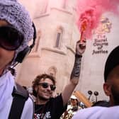 A protester lights a flare outside the Royal Courts of Justice as Palestine Action challenge proscription in a High Court hearing in London on 4 July. The ban, which critics have called draconian, will make it illegal to be a member of the group. (Picture: Leon Neal/Getty Images)