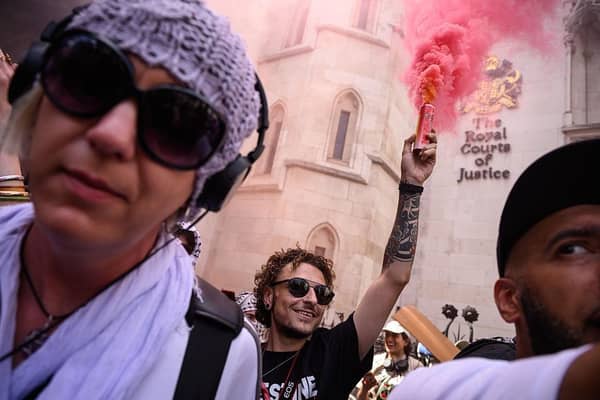 A protester lights a flare outside the Royal Courts of Justice as Palestine Action challenge proscription in a High Court hearing in London on 4 July. The ban, which critics have called draconian, will make it illegal to be a member of the group. (Picture: Leon Neal/Getty Images)