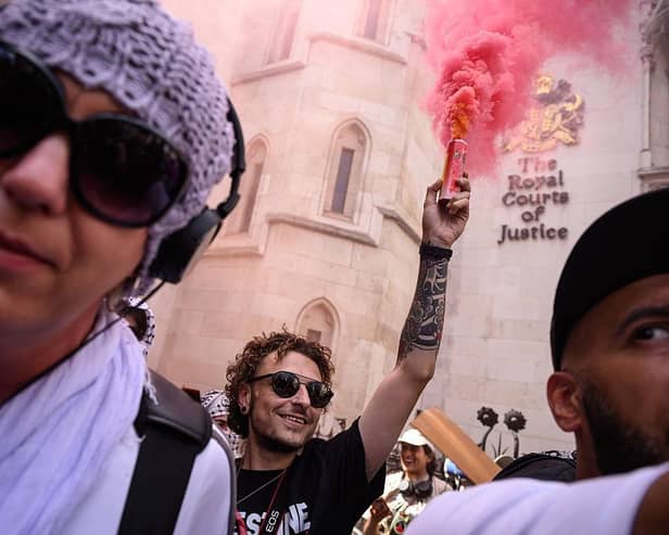 A protester lights a flare outside the Royal Courts of Justice as Palestine Action challenge proscription in a High Court hearing in London on 4 July. The ban, which critics have called draconian, will make it illegal to be a member of the group. (Picture: Leon Neal/Getty Images)