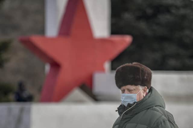 A man walks by a WWII memorial monument in Stanytsia Luhanska, in the Luhansk region, eastern Ukraine, on Friday