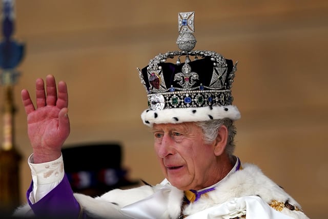 King Charles III receives a royal salute from members of the military in the gardens of Buckingham Place.