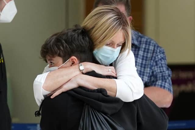 Elaine Burt hugs her nephew Taran after her sister Michelle Bolger and her sons Taran and Kaie arrived on a flight at Glasgow Airport after new travel rules came into force
