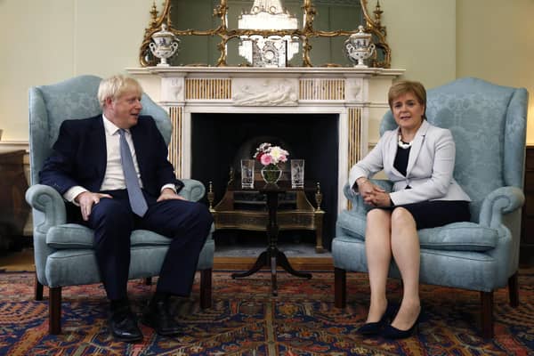 Scotland's First Minister Nicola Sturgeon, right, sits with Britain's Prime Minister Boris Johnson, in Bute House. Mr Johnson has inflamed Scottish discontent with his Conservative government by reportedly saying that giving governing powers to Scotland had been a "disaster". Picture: Duncan McGlynn/Poo Photo via AP, File