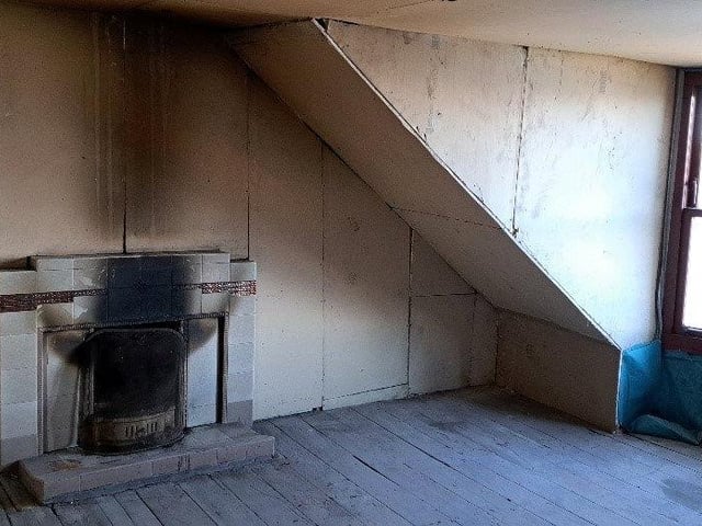 This Victorian attic flat has some original fittings including a porcelain sink and scraps of floral wallpaper. It has no gas connection but does have electricity and running water, and is in a mansion-style fronted house with views over Rothesay Bay.