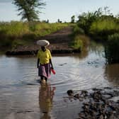A lady crosses land flooded by the rain waters caused by Cyclone Idai, which washed away part of the road, near a village in Phalombe district, southern Malawi. Picture Philip Hatcher-Moore/Oxfam