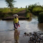 A lady crosses land flooded by the rain waters caused by Cyclone Idai, which washed away part of the road, near a village in Phalombe district, southern Malawi. Picture Philip Hatcher-Moore/Oxfam