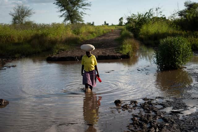 A lady crosses land flooded by the rain waters caused by Cyclone Idai, which washed away part of the road, near a village in Phalombe district, southern Malawi. Picture Philip Hatcher-Moore/Oxfam