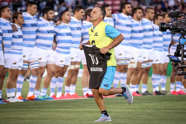 An official from the Argentina team carries an All Blacks jersey with the name Maradona and the number ten printed on it.