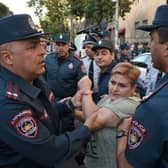 A protester argues with Armenian police officers during a demonstration in Yerevan, following Azerbaijani military operations against Armenian separatist forces in Nagorno-Karabakh.