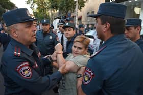 A protester argues with Armenian police officers during a demonstration in Yerevan, following Azerbaijani military operations against Armenian separatist forces in Nagorno-Karabakh.