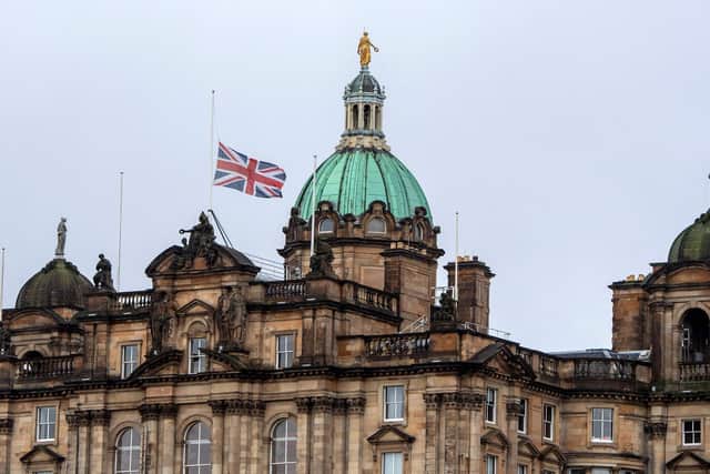 A Union flag flies at half-mast above the Bank of Scotland in Edinburgh on September 9, 2022, a day after Queen Elizabeth II died. (Photo by LESLEY MARTIN/AFP via Getty Images)