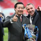 Leicester City's chairman Aiyawatt Srivaddhanaprabha (L) and Leicester City's Northern Irish manager Brendan Rodgers (R) hold the FA Cup trophy in 2021.