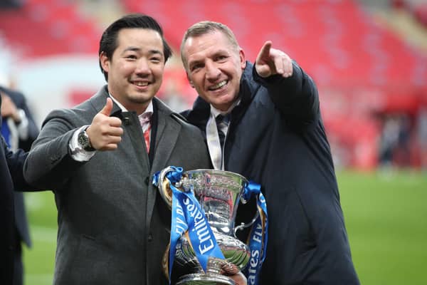 Leicester City's chairman Aiyawatt Srivaddhanaprabha (L) and Leicester City's Northern Irish manager Brendan Rodgers (R) hold the FA Cup trophy in 2021.