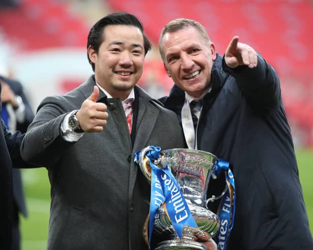 Leicester City's chairman Aiyawatt Srivaddhanaprabha (L) and Leicester City's Northern Irish manager Brendan Rodgers (R) hold the FA Cup trophy in 2021.