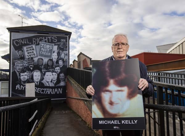 John Kelly, brother of Michael Kelly, who was killed on Bloody Sunday in Derry's Bogside in 1972, holds an image of his brother beside the Civil Rights mural in the city. The campaigner has told how he narrowly avoided being shot on the same day his teenage brother was killed. Photo: Liam McBurney/PA Wire