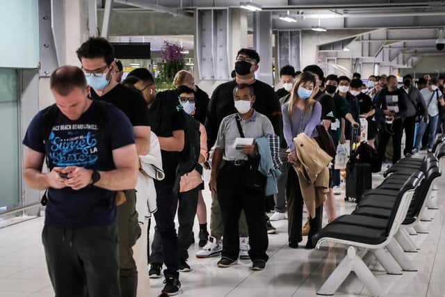 Incoming passengers line up to have their temperatures taken and health assessed at a checkpoint for people flying in from a list of countries that include China, Hong Kong, Macau, South Korea, Iran and Italy, as a precautionary measure against the spread of the Covid-19 novel coronavirus in Thailand.