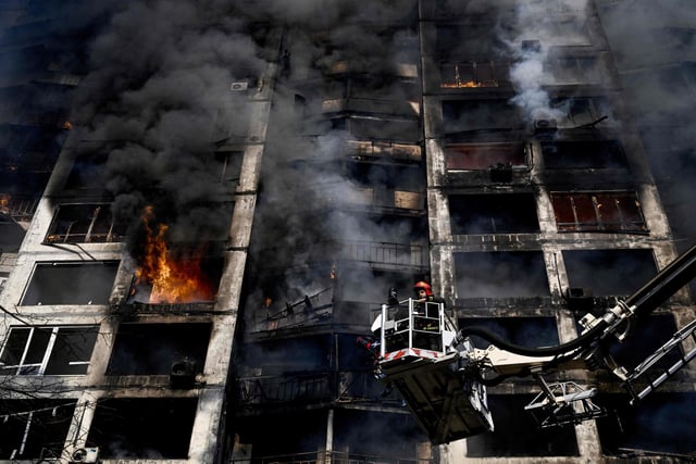 Firefighters battle a fire at an apartment after strikes on residential areas killed at least two people, Ukraine emergency services said as Russian troops intensified their attacks on the Ukrainian capital. Photo by Aris Messinis / AFP via Getty