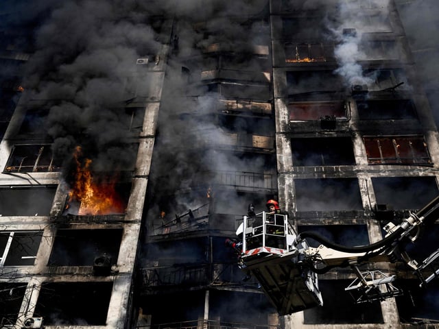 Firefighters battle a fire at an apartment after strikes on residential areas killed at least two people, Ukraine emergency services said as Russian troops intensified their attacks on the Ukrainian capital. Photo by Aris Messinis / AFP via Getty