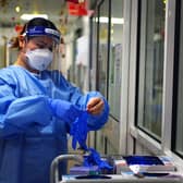 File photo dated 21/12/2021 of a nurse puts on PPE in a ward for Covid patients