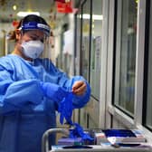 File photo dated 21/12/2021 of a nurse puts on PPE in a ward for Covid patients