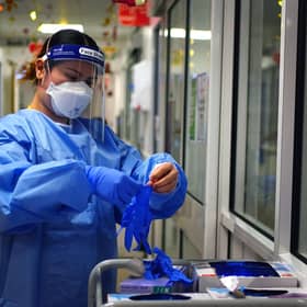 File photo dated 21/12/2021 of a nurse puts on PPE in a ward for Covid patients