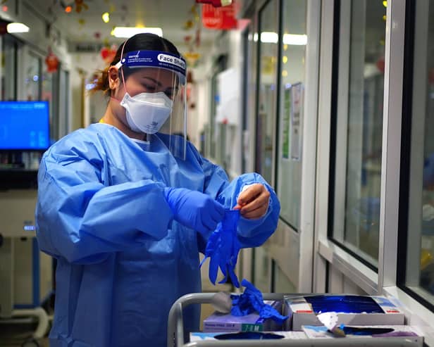 File photo dated 21/12/2021 of a nurse puts on PPE in a ward for Covid patients