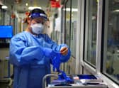 File photo dated 21/12/2021 of a nurse puts on PPE in a ward for Covid patients