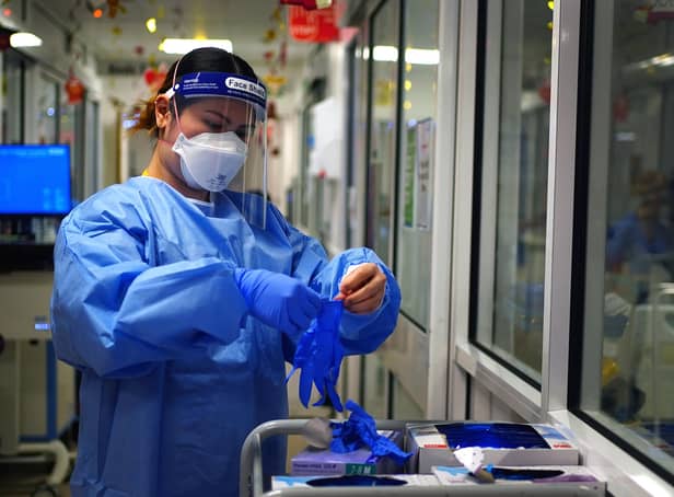 File photo dated 21/12/2021 of a nurse puts on PPE in a ward for Covid patients