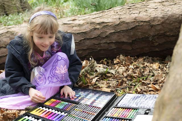 Young girl, Zoe Downing enjoying coloured crayons and pens outdoors in woodland.
The Teapot Trust RHS Chelsea Flower Show 2023 Elsewehere Garden by Semple Begg Design.

Photography © Andrea Jones