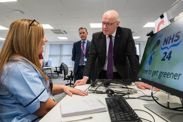 First Minister John Swinney with call handler Angela Martin, during his visit to the NHS 24 call centre in Dundee. Picture: Alan Richardson/PA Wire