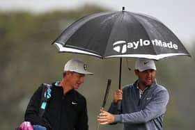 World No 1 Scottie Scheffler of the United States and his caddie Ted Scott look on from under an umbrella during the second round of the Genesis Scottish Open at The Renaissance Club. Picture: Jared C. Tilton/Getty Images.