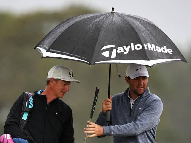 World No 1 Scottie Scheffler of the United States and his caddie Ted Scott look on from under an umbrella during the second round of the Genesis Scottish Open at The Renaissance Club. Picture: Jared C. Tilton/Getty Images.