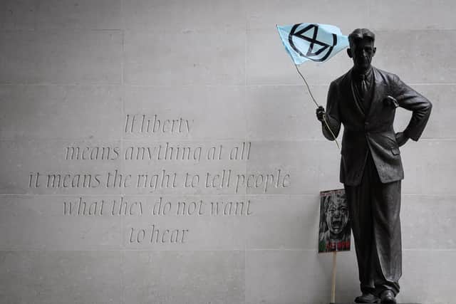 An Extinction Rebellion flag is seen in the hands of a statue of George Orwell outside the headquarters of the BBC in London, October 2019 PIC: Leon Neal/Getty Images