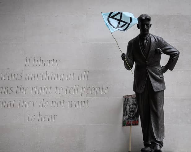 An Extinction Rebellion flag is seen in the hands of a statue of George Orwell outside the headquarters of the BBC in London, October 2019 PIC: Leon Neal/Getty Images