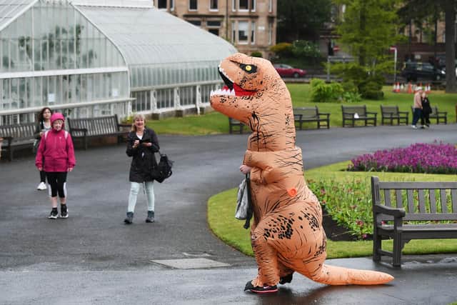 People in the Glasgow Botanics are impressed with Pamela Livingstone's T-Rex costume.